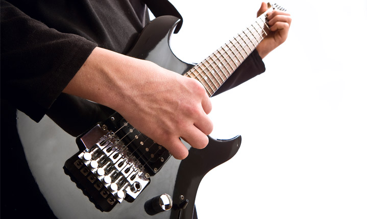 A close up of a man playing an electric guitar